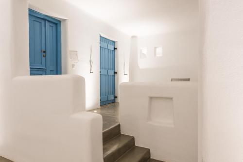 a hallway with stairs and a blue door at Cycladic Islands Hotel & Spa in Agia Anna Naxos