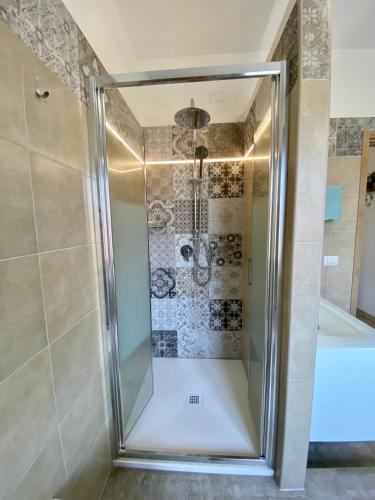 a shower with a glass door in a bathroom at Secret Paradise & SPA Rooftop in Quartu SantʼElena