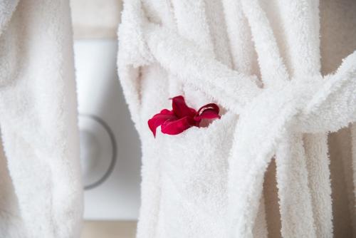a white towel with a red flower on it at Cycladic Islands Hotel & Spa in Agia Anna Naxos
