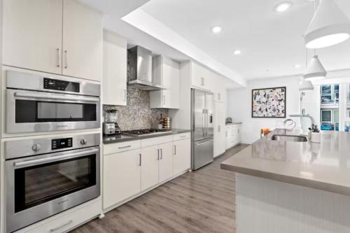 a large white kitchen with stainless steel appliances at Ruby Tide - Two Floor Airy 2BR Marina Side Exclusive Amenities in Los Angeles