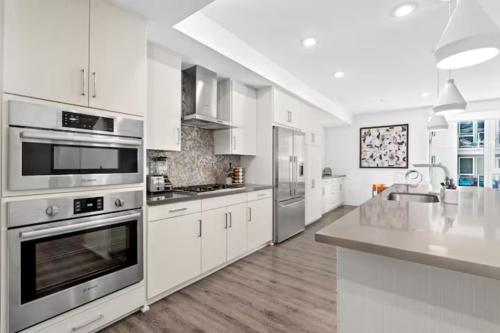 a large white kitchen with stainless steel appliances at Luxurious 2-Bedroom 2-Bath Unit with Marina Views in Los Angeles