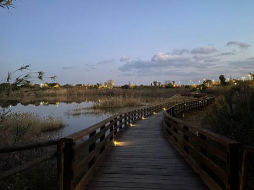 a wooden bridge over a river with lights on it at Secret Paradise & SPA Rooftop in Quartu SantʼElena