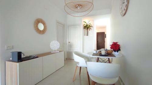 een witte keuken met een tafel en witte stoelen bij Residential Golf Park - Casa Prezi in San Miguel de Abona