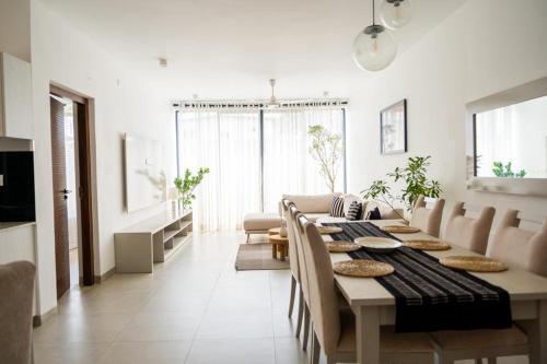 a dining room with a table and a living room at Zayn villa in Mount Lavinia