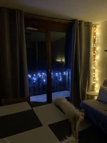 a bedroom with a window with christmas lights at Appartement au pied des pistes in Châtel