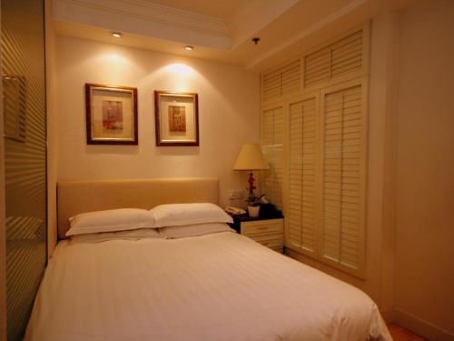 a bedroom with a bed with white sheets and pillows at Mingle At The Eden in Hong Kong