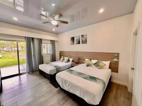 a bedroom with two beds and a ceiling fan at Villa Cielo, Casa de playa in Jacó