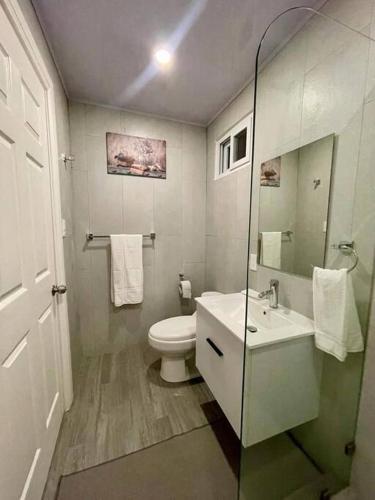 a white bathroom with a toilet and a sink at Villa Cielo, Casa de playa in Jacó