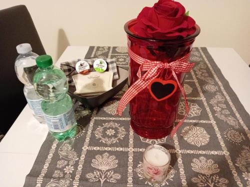 a red vase with roses in it on a table at Lusitana Alloggi in Foligno