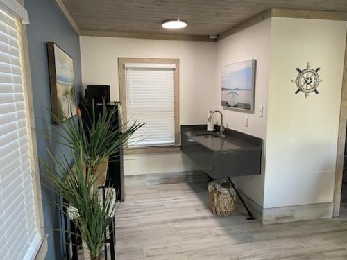 ein Badezimmer mit einem Waschbecken und einer Uhr an der Wand in der Unterkunft Gulf Coast Inn in Gulf Breeze