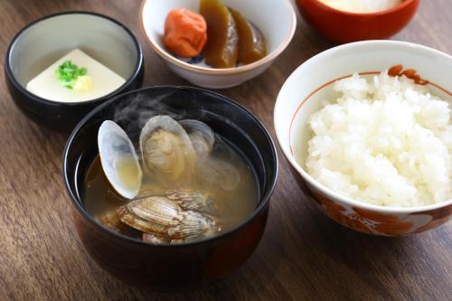 a group of bowls of food with seafood and rice at Dormy Inn Premium Ginza - Natural Hot Spring in Tokyo