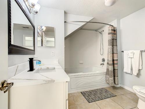 ein weißes Badezimmer mit Waschbecken und Badewanne in der Unterkunft 4 Bedroom Townhouse in a Gated Resort! in Kissimmee