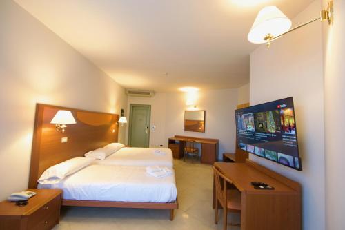 ein Hotelzimmer mit einem Bett und einem Flachbild-TV in der Unterkunft Touring Hotel 