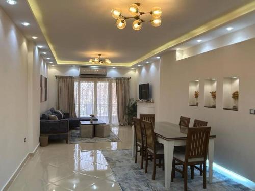 a living room with a table and chairs and a couch at New furnished apartment in Cairo