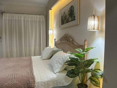 a bedroom with a bed with white sheets and a plant at New furnished apartment in Cairo