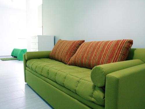 a green couch with a pillow on top of it at Residence Le Isole in Marsala