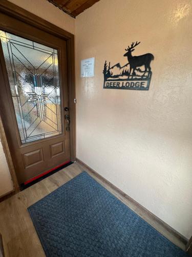 Zimmer mit einer Tür mit einem Hirschschild an der Wand in der Unterkunft Deer Lodge in Red River