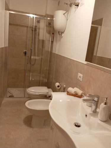 a bathroom with a sink and a toilet and a shower at Lusitana Alloggi in Foligno