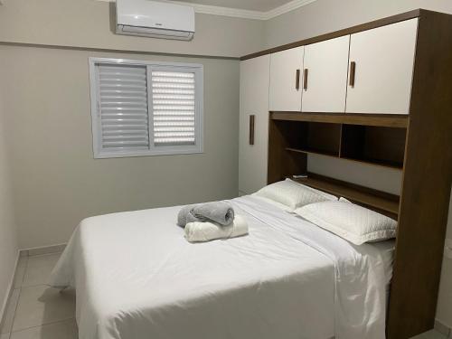 利梅拉的住宿－Apartamento próximo ao Pão de Açúcar e centro，一间卧室配有一张带白色床单的床和一扇窗户。