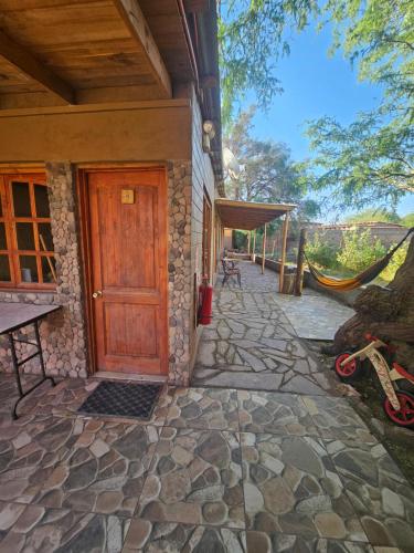 a house with a wooden door and a patio at Hostal Casa los Duendes in San Pedro de Atacama