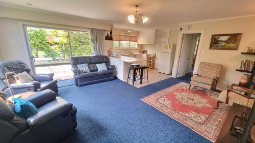 a living room with two couches and a kitchen at 2 Alpine Avenue in Hanmer Springs