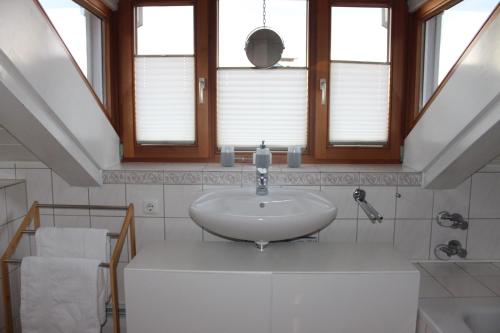 baño con lavabo, espejo y ventanas en Ferienwohnung Bernau, en Bernau am Chiemsee