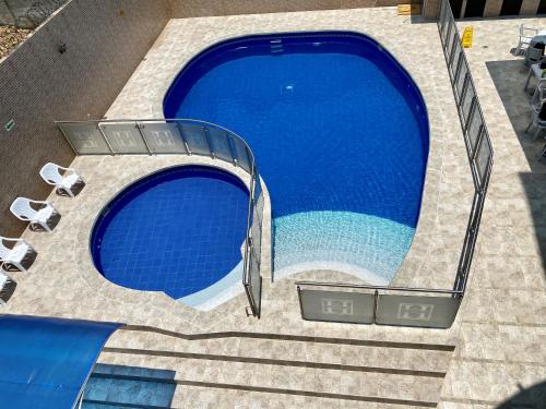 an overhead view of a swimming pool with stairs and chairs at Hotel Calle Real Inn in Aguachica