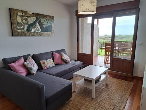 - un salon avec un canapé et une table dans l'établissement Playa del prado, à Ribeira
