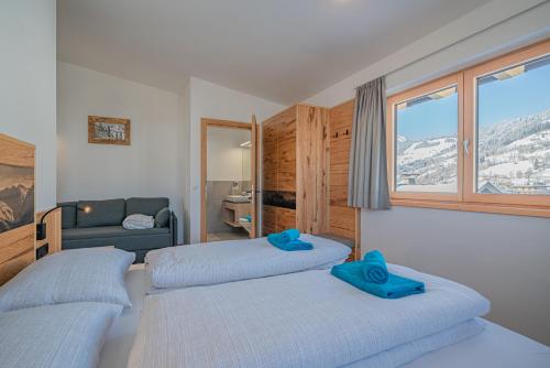 ein Schlafzimmer mit 2 Betten und blauen Hausschuhen darauf in der Unterkunft Appartement Andrea Cäciel in Brixen im Thale