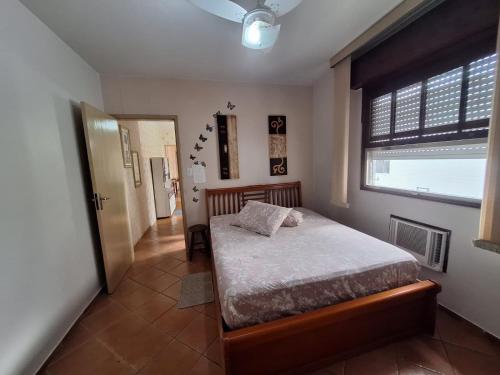 a bedroom with a bed and a large window at Apartamento em São Vicente in São Vicente