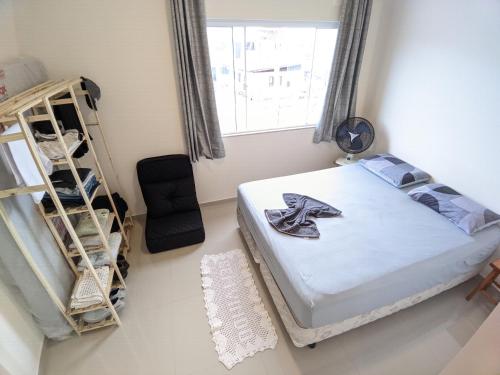 een slaapkamer met een bed, een ladder en een raam bij Sobrado aconchegante 2 suítes, 2 vagas garagem, 3 banheiros in Itapema
