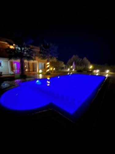 a blue swimming pool at night with a house at Villa Haitam Marrakech in Oubadine