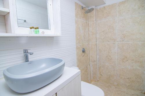 a white bathroom with a sink and a shower at Casa Playa James in Los Arrayanes