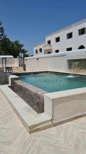 a swimming pool in front of a building at Raya in Midoun