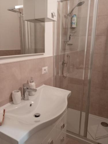 a bathroom with a white sink and a shower at Lusitana Alloggi in Foligno
