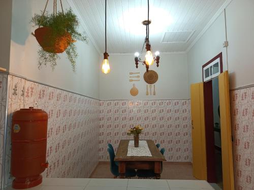 a room with a table and chairs and pendant lights at É Hostel - Guesthouse in Ouro Preto
