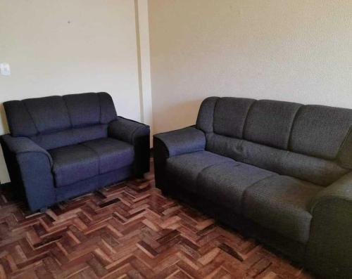 a living room with a couch and a chair at Apartamento Saquarema Centro in Saquarema