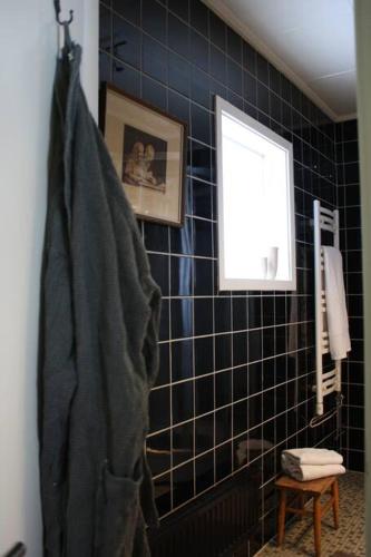 a bathroom with black tiled walls and a window at Villa Lillebo in Bengtsfors