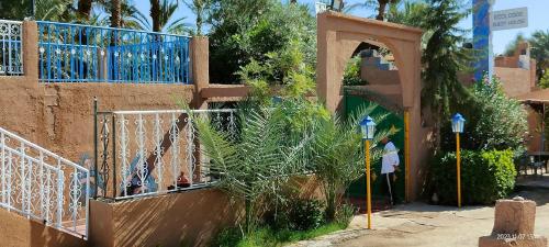 una puerta a un edificio con un arco y una persona en Ecolodge du Draa, en Ouled Otmane