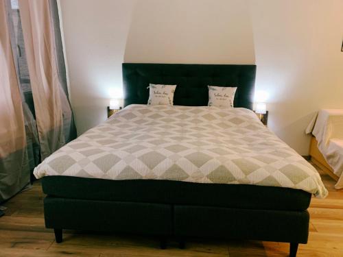 a bedroom with a large bed with a green headboard at Family Apartment MiniGlück in Sankt Englmar
