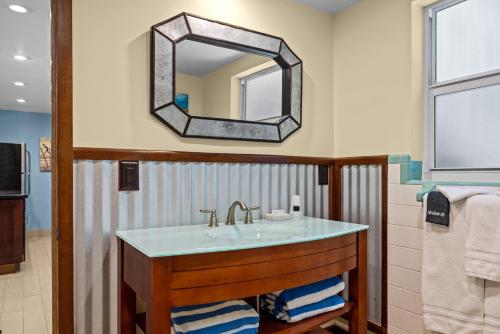 a bathroom with a sink and a mirror at Sun Dek Beach House in Boynton Beach