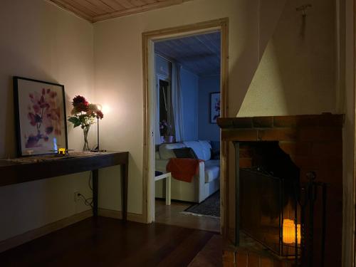 a living room with a fireplace and a bedroom at Lillhuset in Järbo