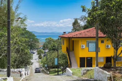 une maison jaune sur le côté d'une rue dans l'établissement Pousada Sabores do Mar Laranjeiras, à Balneário Camboriú