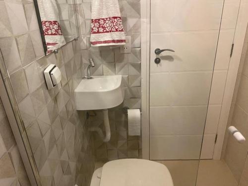 a small bathroom with a toilet and a sink at Casa do Jardim in Curitiba