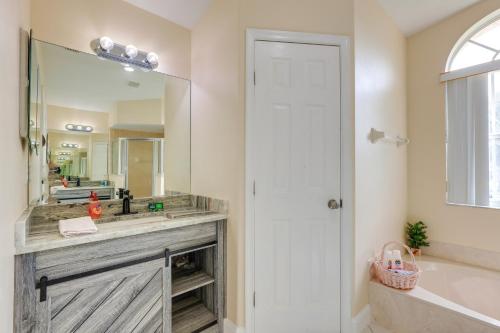 een badkamer met een wastafel, een bad en een spiegel bij Port St Lucie Home about 15 Mi to Jensen Beach Park! in Port Saint Lucie