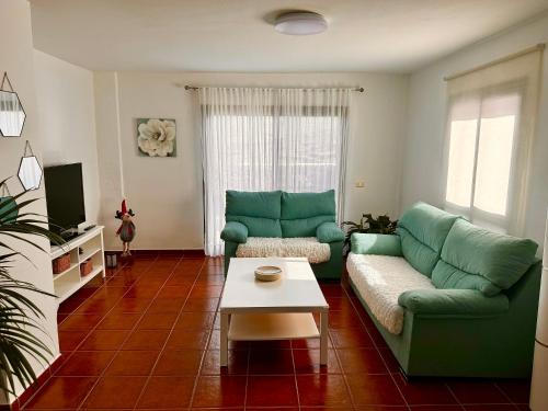 a living room with a green couch and a coffee table at La casa de Tenesedra in Mocanal