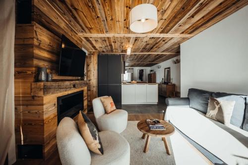 a living room with a white couch and a fireplace at Nards furnished chalet in Praz-sur-Arly