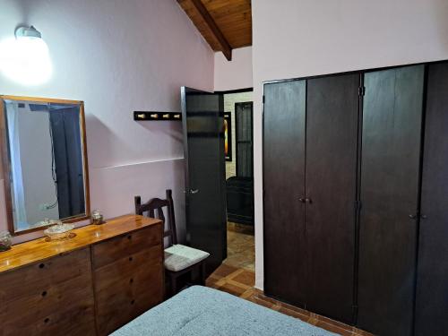 um quarto com uma cómoda de madeira e um espelho em Lo de Mijo - Cerca de Parque Termal Dolores em Dolores