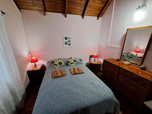 um quarto com uma cama com um edredão azul e um espelho em Lo de Mijo - Cerca de Parque Termal Dolores em Dolores