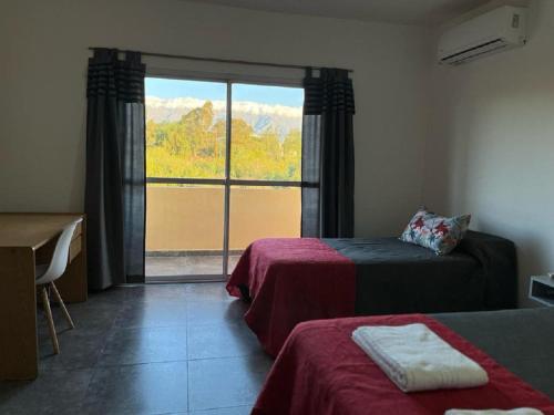 a room with two beds and a large window at Complejo “Aloe Vera” in Villa Dolores